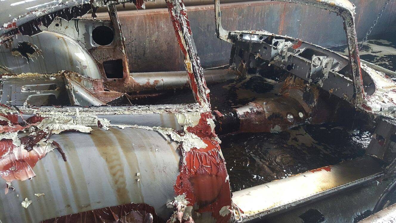 Karosserie im Entlackungsbad – die Beschichtung löst sich vom Untergrund